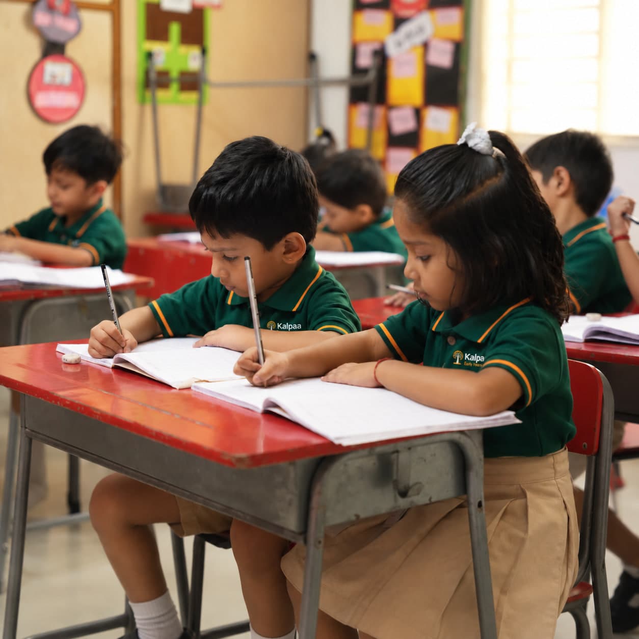 Children practising their writing in ruled notebooks