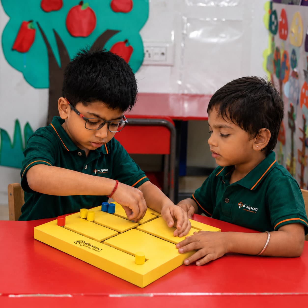 Two Kalpaa children working a wooden puzzle board