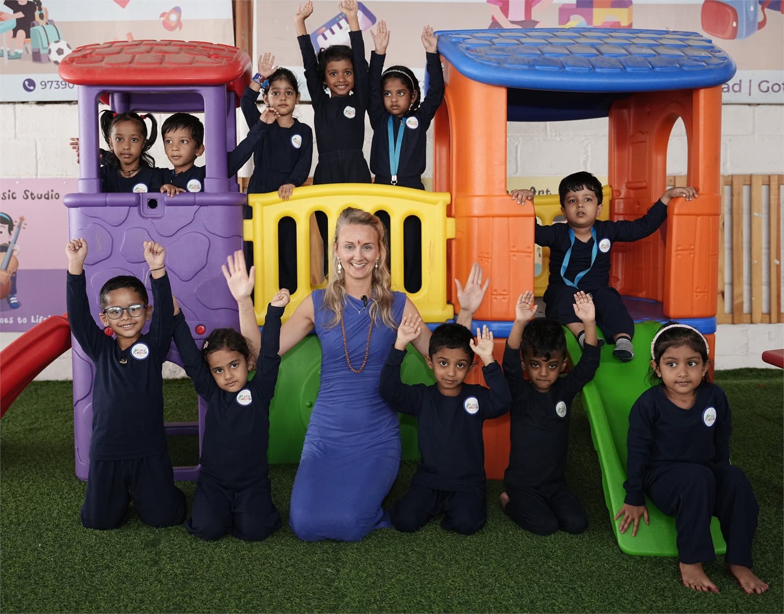 Kalpaa's Finland Associate with a group of children beside the outdoor playhouse